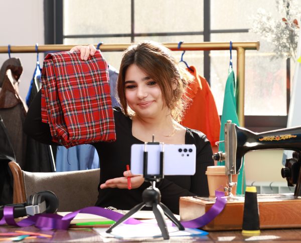 Cute tailor showing her fabric to the phone